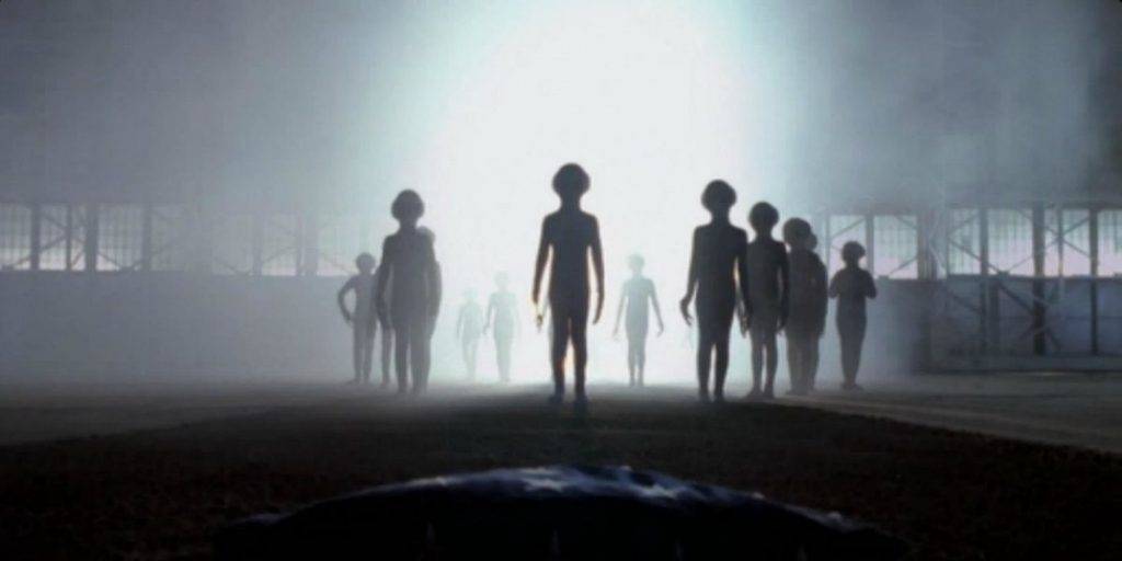 una scena con l'arrivo degli alieni in X Files, in penombra con luce accecante alle spalle 