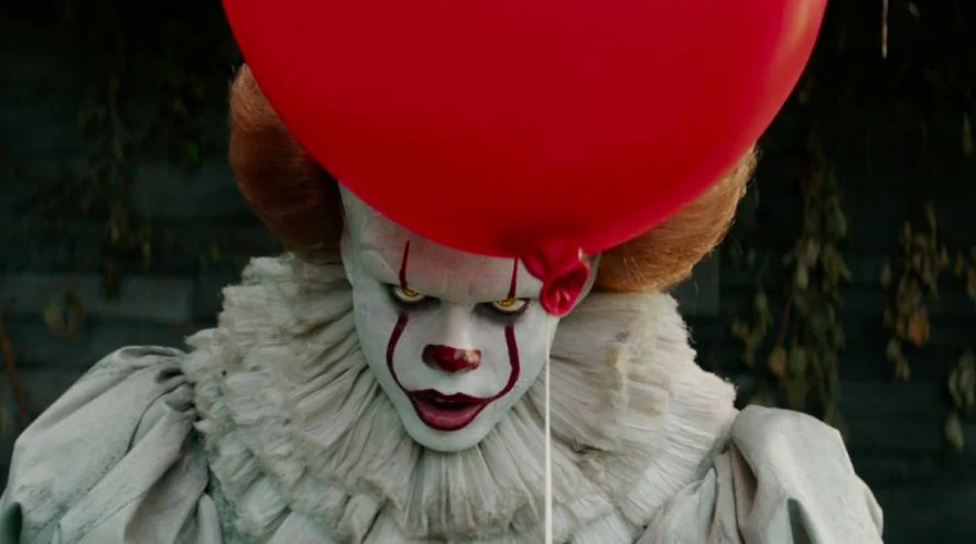 il clown Pennywise nel film horror It, col palloncino tra le mani